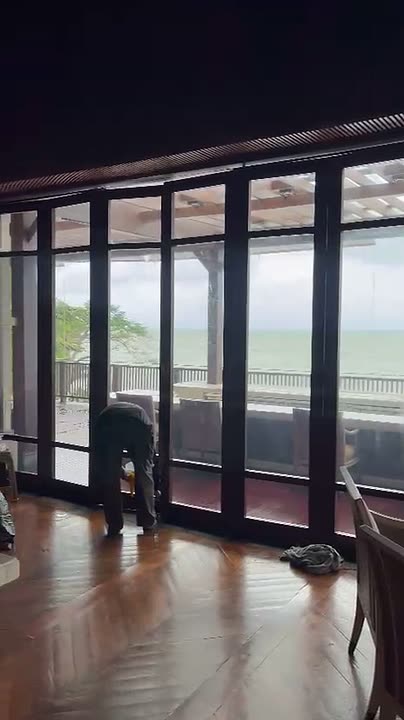 Pemasangan kaca film pada kaca tinggi restoran menggunakan tangga